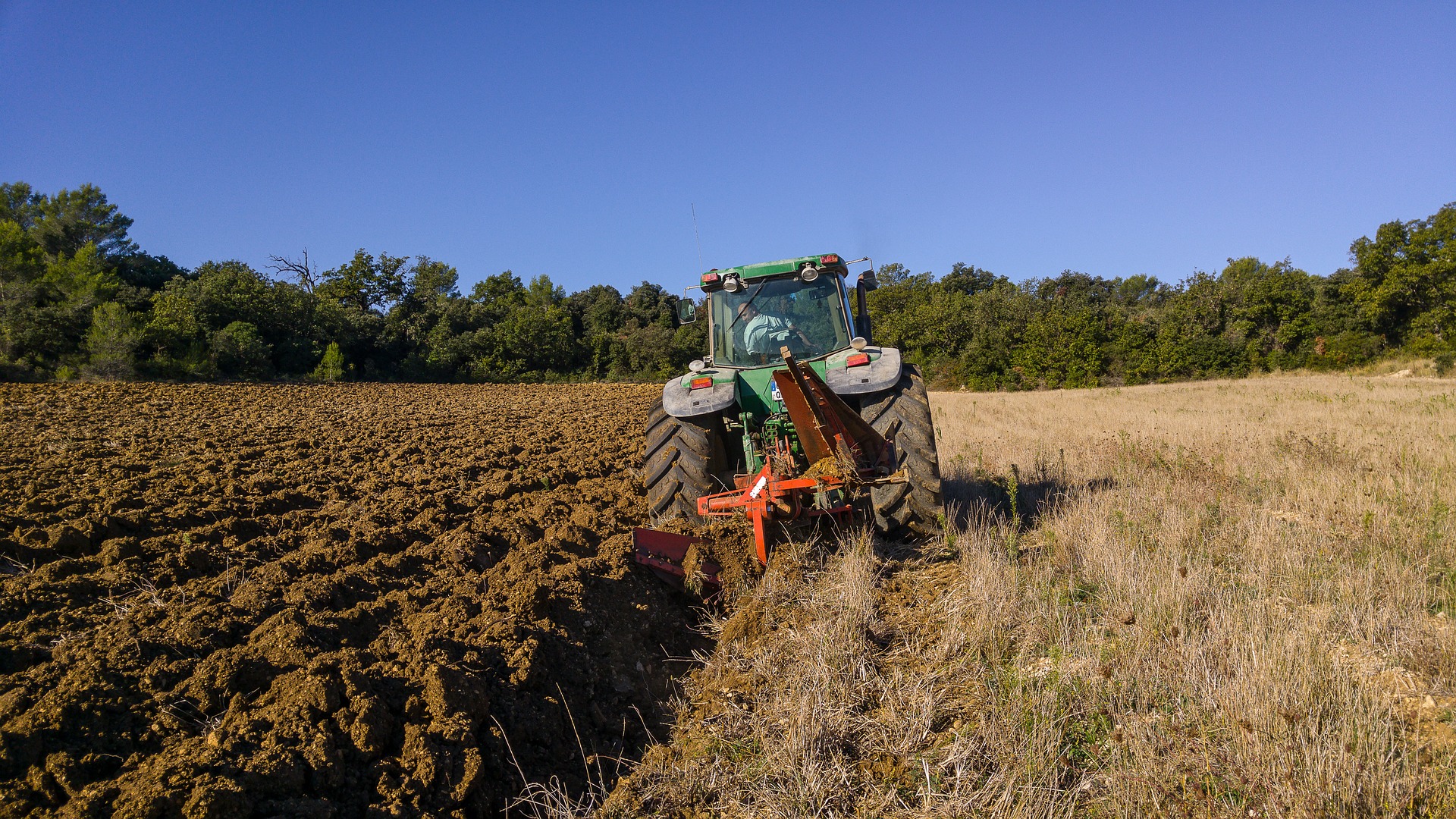 Bilden visar en harv monterad på en veterantraktor, du hittar traktortillbehör och reservdelar till traktorer hos exempelvis sagro.se